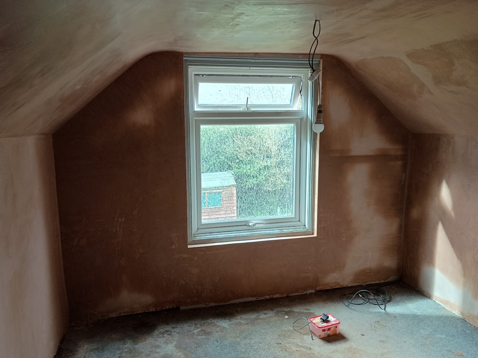 A sloped loft room freshly plastered ready for decorating